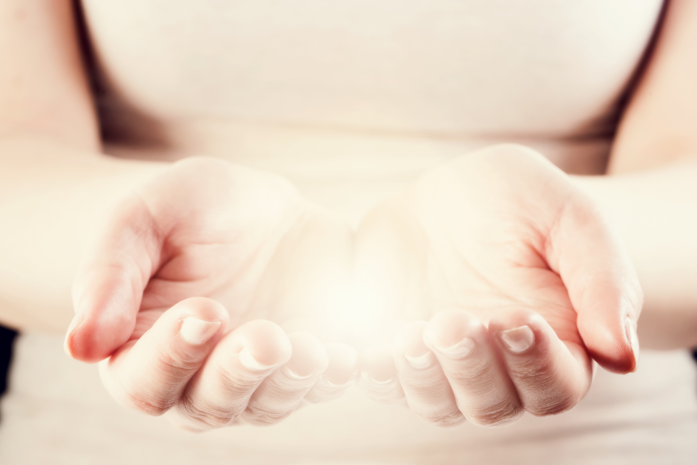 Light in woman hands. Giving, protect, care, energy concept.
