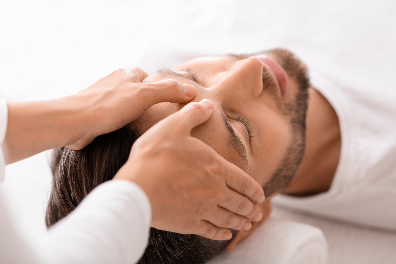 Peaceful man getting healing head massage at spa